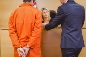 incarcerated man with lawyer talking to judge